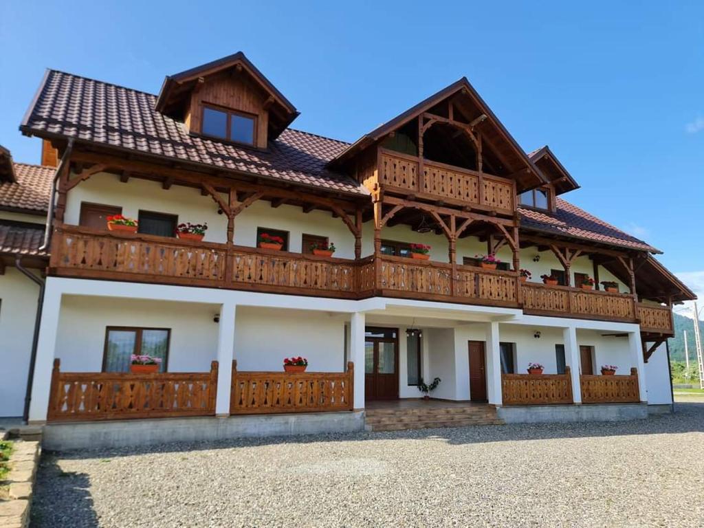 a large house with a wooden roof at Casa Loredana in Vadu Izei