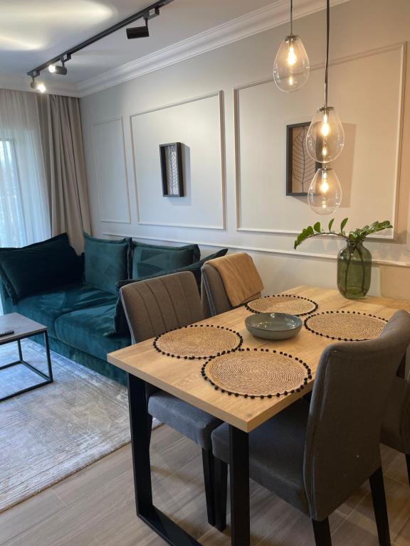 una sala de estar con una mesa y un sofá en Apartamenty na wydmach RB, en Międzywodzie