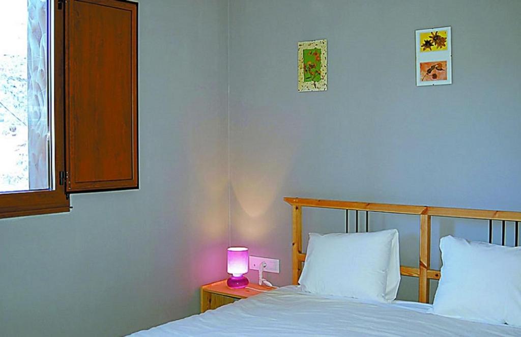 a bedroom with a bed with a lamp on a night stand at Casa Do Ferreiro - La Fragua in Las Herrerías