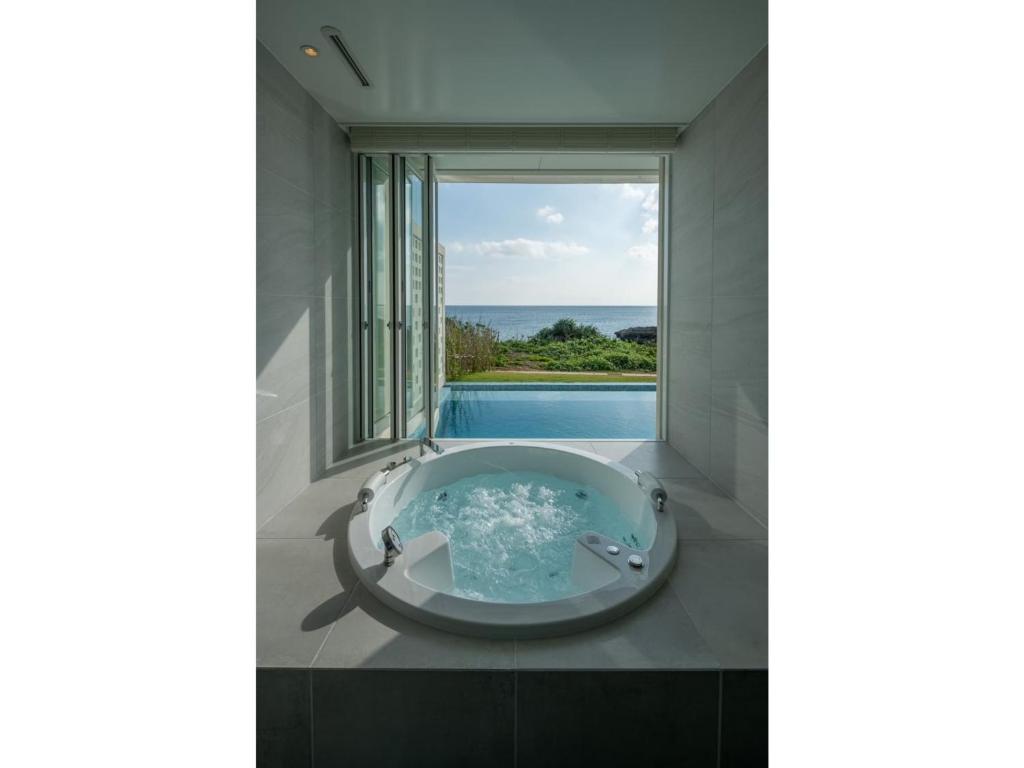 une baignoire dans une salle de bain avec une grande fenêtre dans l'établissement ilove385 - Vacation STAY 16960, à Kuninaka