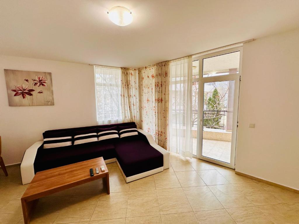 a bedroom with a bed and a table in it at Charming 2-bed flat with pool view in Sunny Beach, Bulgaria in Sunny Beach