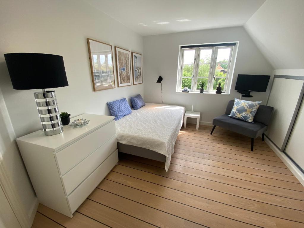 una piccola camera con letto e sedia di Private Rooms - Køge a Køge
