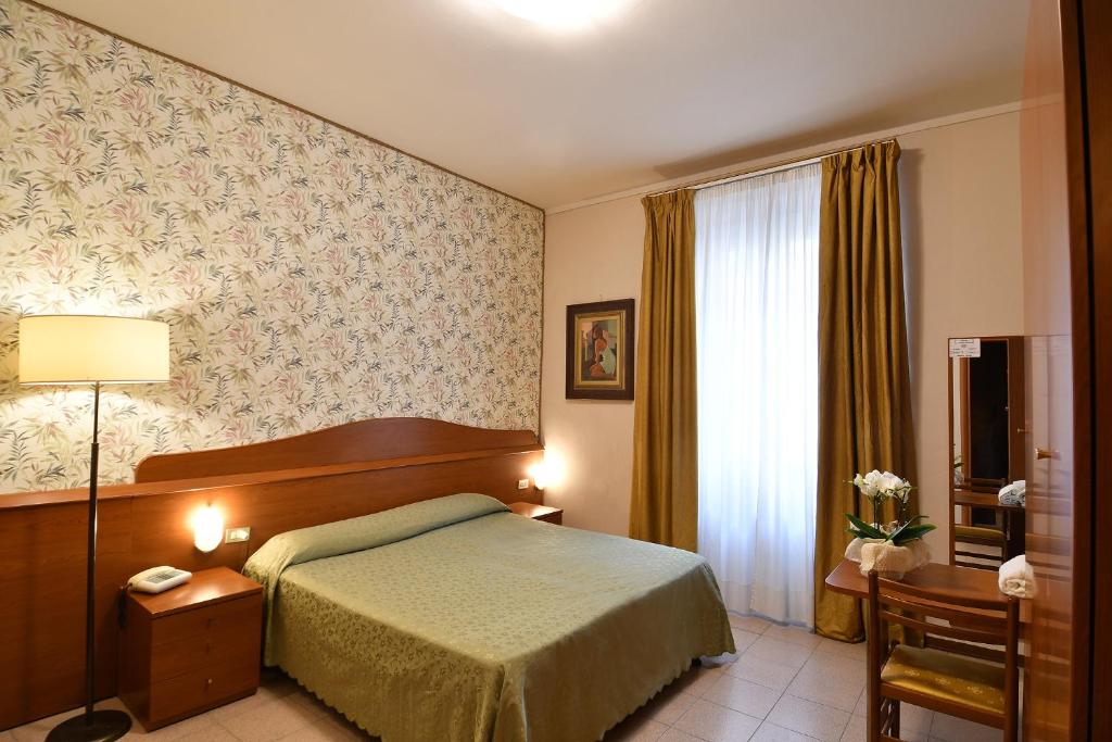 Postel nebo postele na pokoji v ubytování Hotel Innocenti