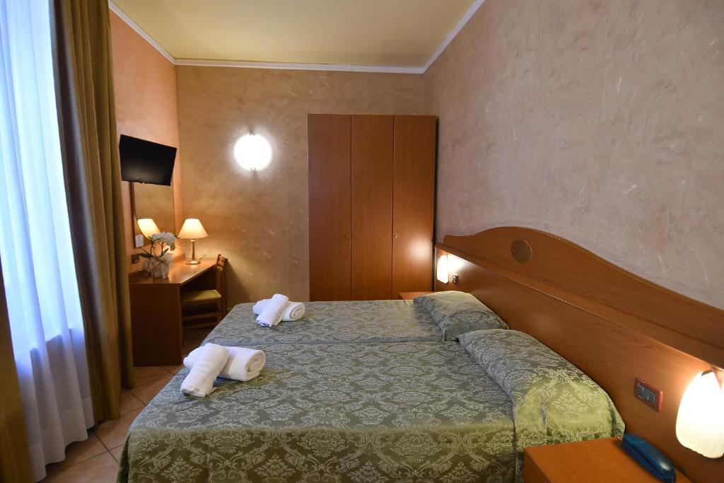 Postel nebo postele na pokoji v ubytování Hotel Innocenti