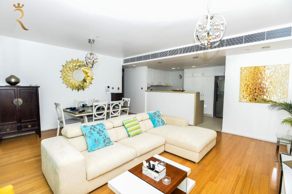 a living room with a couch and a table at Al Raha Serenity - Spacious 2BR Getaway Near Yas Island & Al Raha Beach in Abu Dhabi