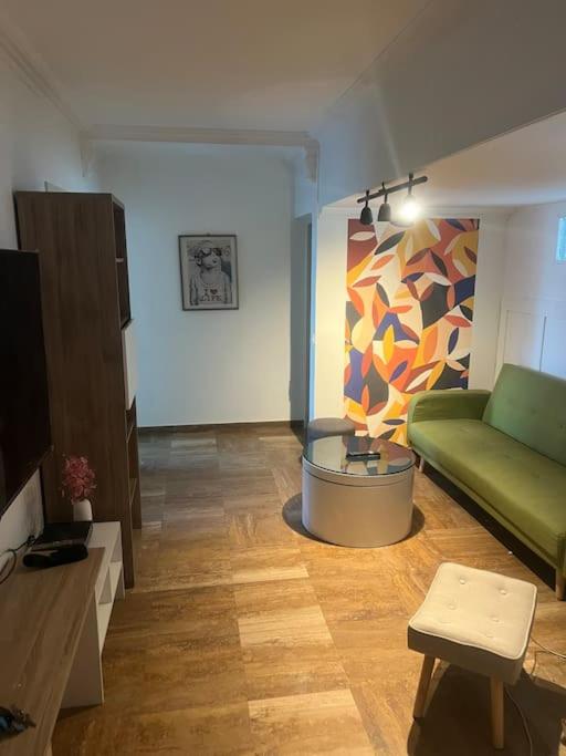 un salon avec un canapé vert et une table dans l'établissement Appartement super équipé pour 4 personnes, à Toulouse