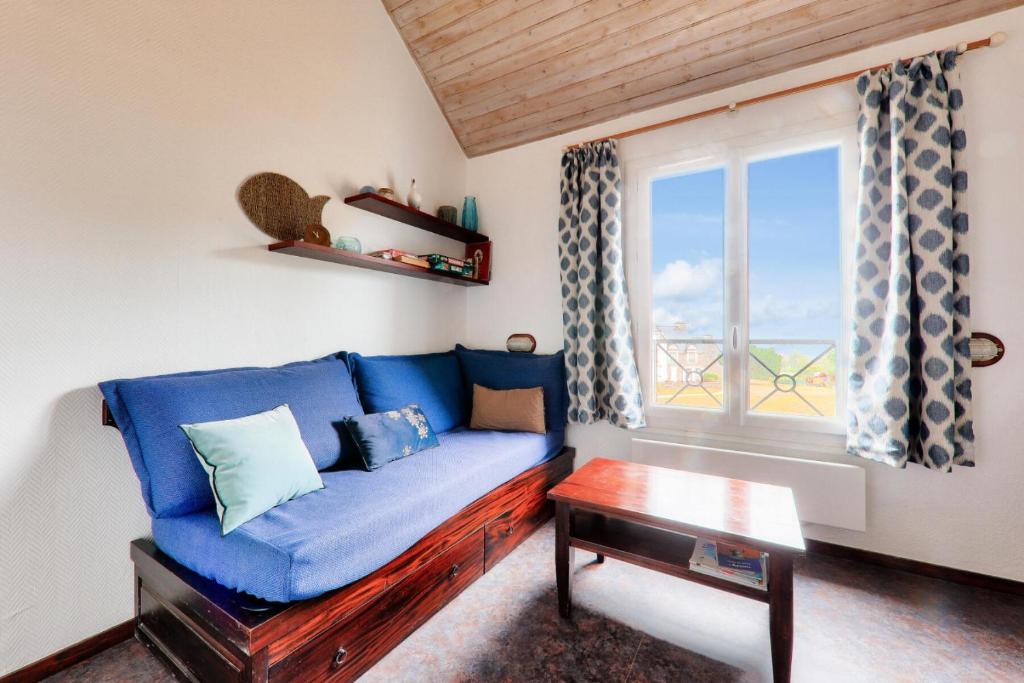 un salon avec un canapé bleu et une fenêtre dans l'établissement Résidence Port du Crouesty - maeva Home - Appartement 4 pièces 6 personnes vue mer - Sélection MAE-2251, à Arzon