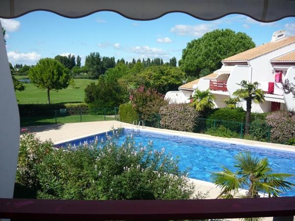 uma piscina em frente a uma casa e a uma casa em Green Village em La Grande-Motte