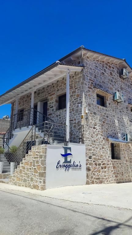 a stone building with a sign in front of it at Evaggelia's Stone Suites in Skala Marion