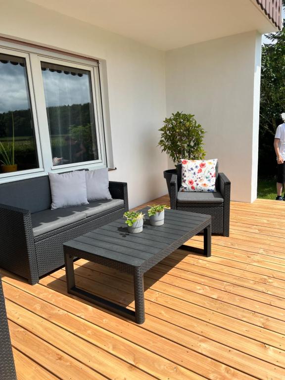 a patio with a table and chairs on a deck at Ferienhaus am Schorren in Bad Schussenried