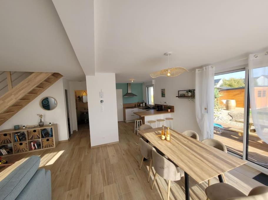 une salle à manger et un salon avec une table et des chaises dans l'établissement Coup de coeur à Pors Carn, à Penmarcʼh