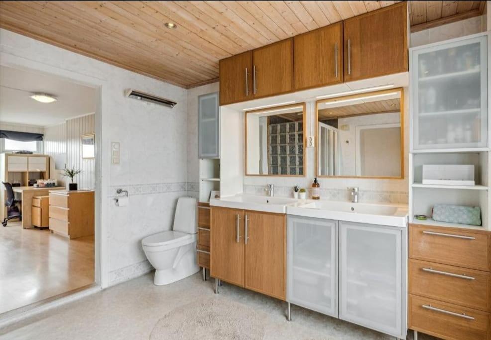 Un baño con dos lavabos y un inodoro. en Casa Melkhaugen, en Veiholmen