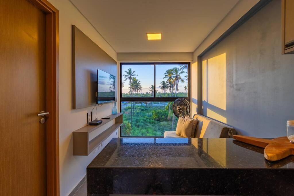 a kitchen with a counter and a large window at Marina do Cupe 302 in Porto De Galinhas