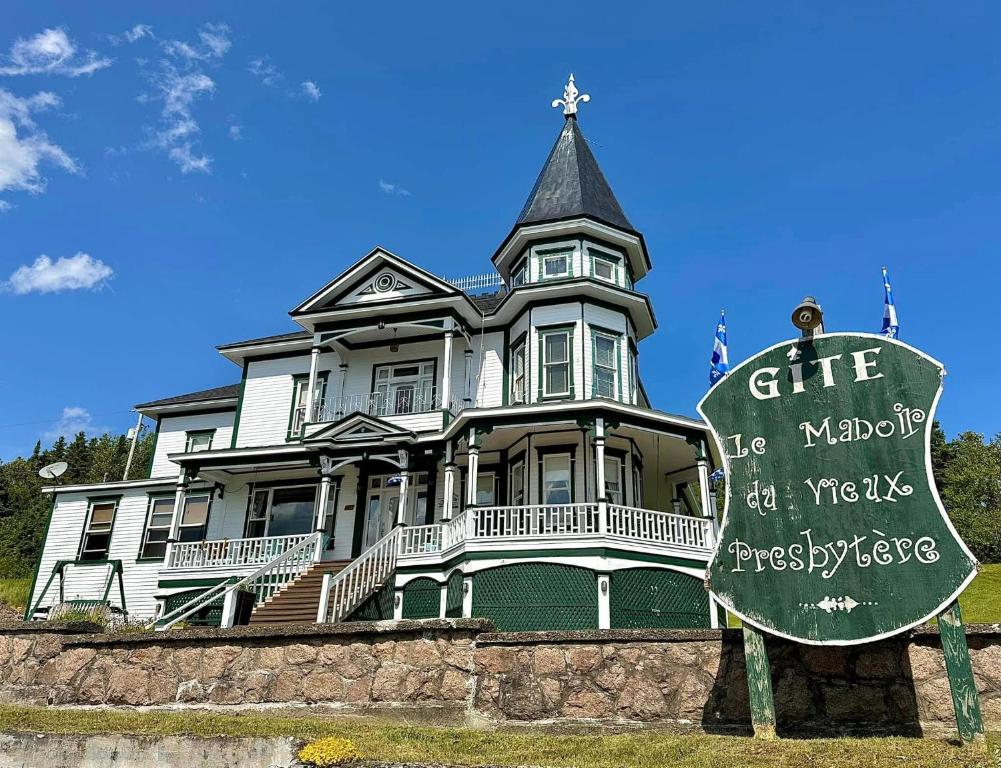 a large house with a sign in front of it at Le Manoir du Vieux Presbytère in Port-Daniel