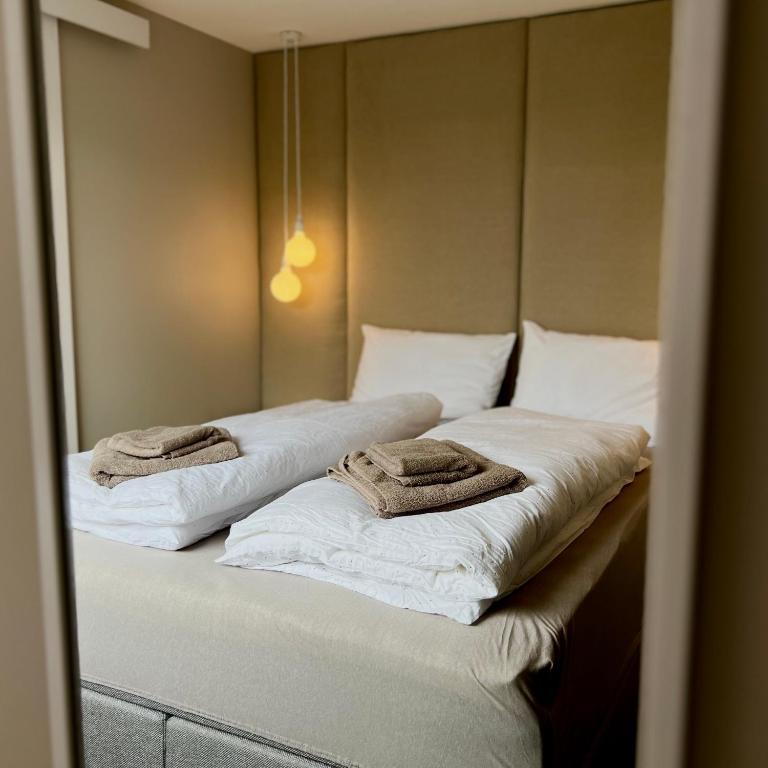 two towels are sitting on top of two beds at Cozy Central Apartment in Ålesund in Ålesund