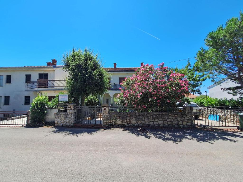 a house with a stone fence and pink flowers at Apartment Harmonia in Dramalj