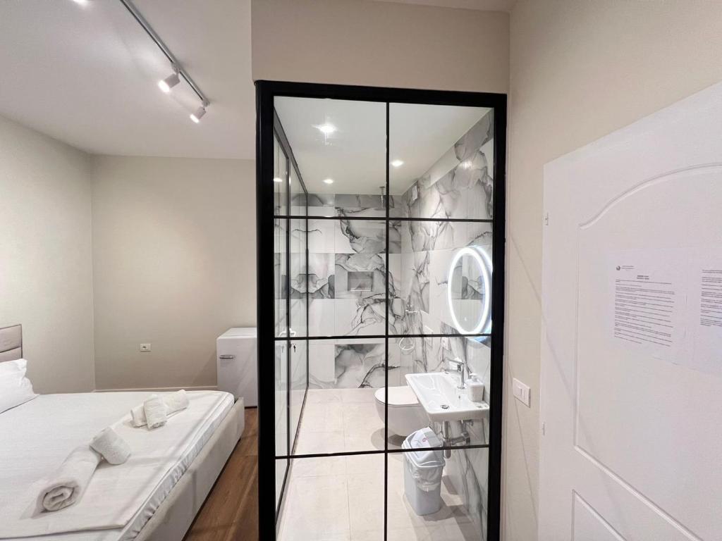 um quarto com uma cabina de duche em vidro e um lavatório em Serene Stay em Vlorë