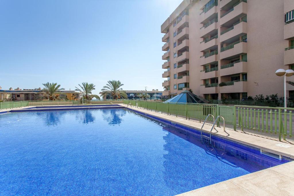 una gran piscina azul junto a un edificio en Apartment Patacona Beach 7, en Valencia