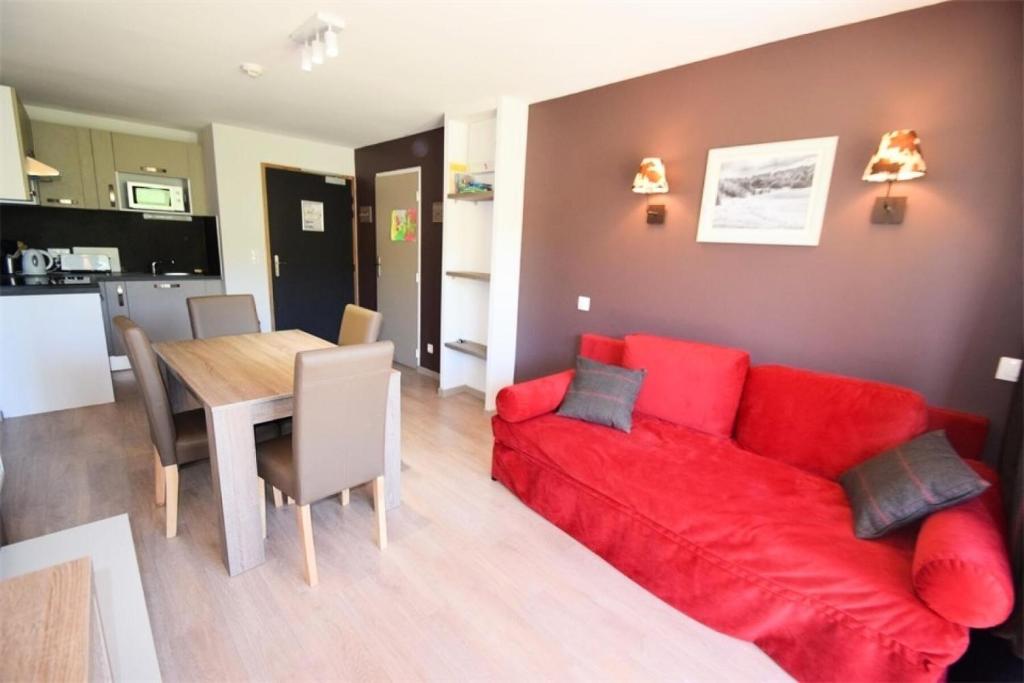 un salon avec un canapé rouge et une table dans l'établissement Résidence Front De Neige - 3 Pièces 6 pers LE FRONT DE NEIGE - WIFI PLAGNE VILLAGES MAE-9384, à Aime La Plagne