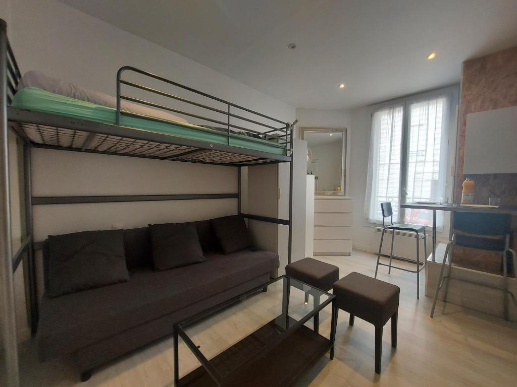 un salon avec un lit superposé et un canapé dans l'établissement Studio proche Paris, à Maisons-Alfort