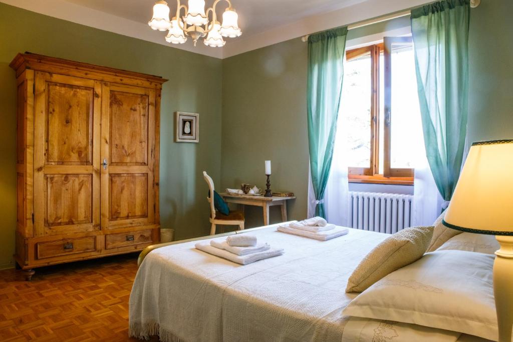 een slaapkamer met een bed, een dressoir en een raam bij Casa Aloe B&B in Monte San Savino