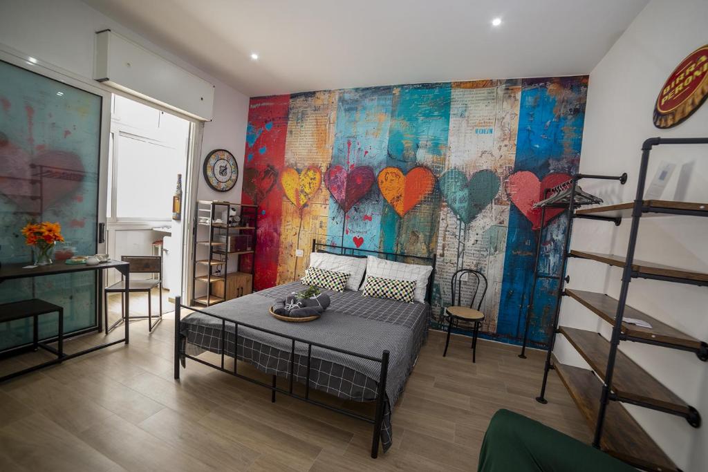Un dormitorio con un mural de corazones en la pared. en La portineria guest house, en Bari