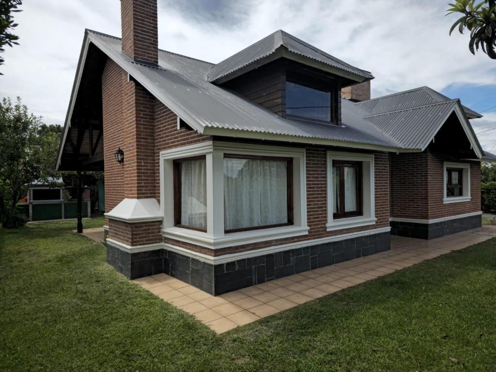 a house with a metal roof on a lawn at Casa Chalet in Ostende