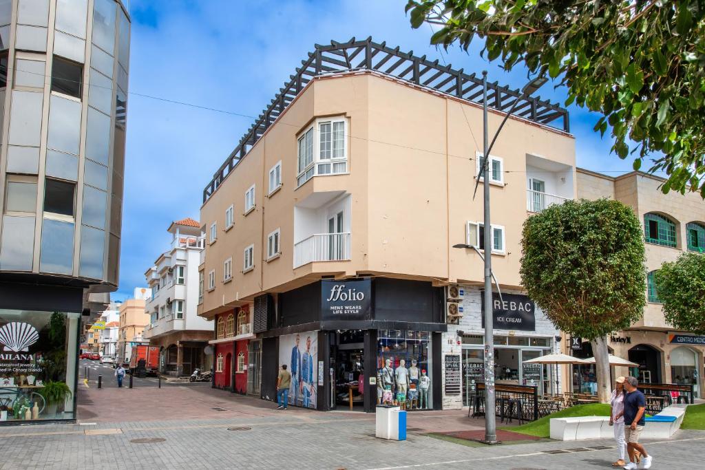a building on the corner of a street with shops at Calas Beach Corralejo in Corralejo