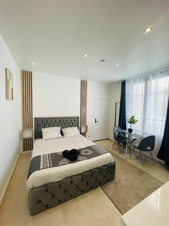 une chambre avec un grand lit et une table dans l'établissement Le Falcon Proche de Aeroport et Parc Exposition, au Bourget