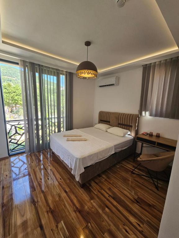 a bedroom with a bed and a table and windows at La Vida Apartments in Babalonija