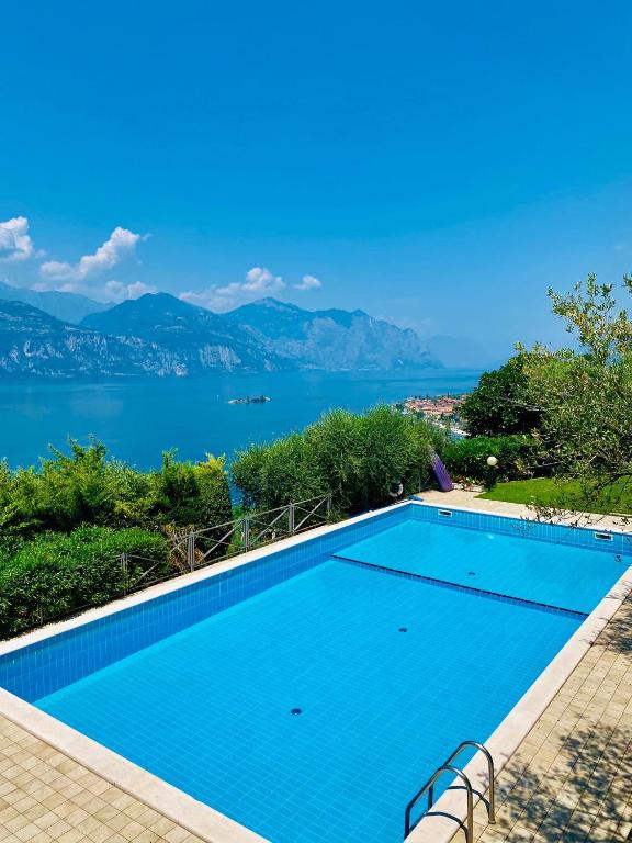 a swimming pool with a view of the water at WELCOME TRAVELLER Charm Montees Apartment in Brenzone sul Garda