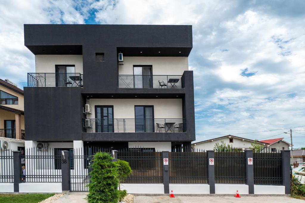 ein schwarzweißes Gebäude hinter einem Zaun in der Unterkunft Casa Mathias in Eforie Nord