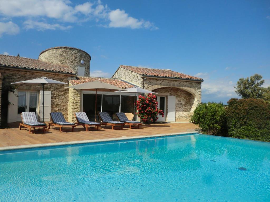 a villa with a swimming pool in front of a house at La maison de Inna in Bonnieux