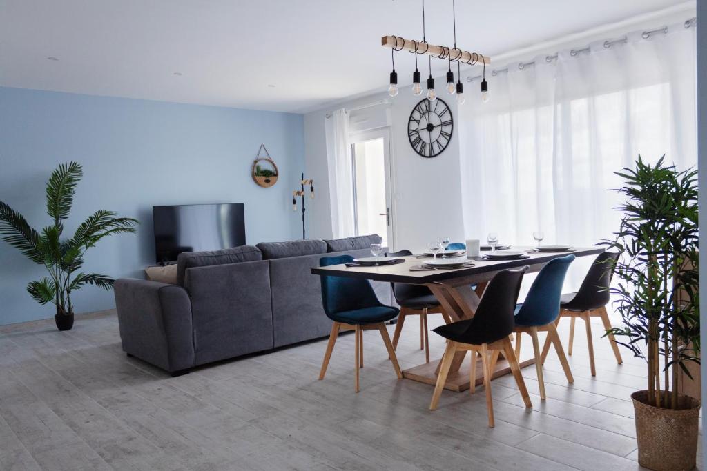 a living room with a couch and a table and chairs at Résidence Campagne Charentaise in Val-de-Bonnieure