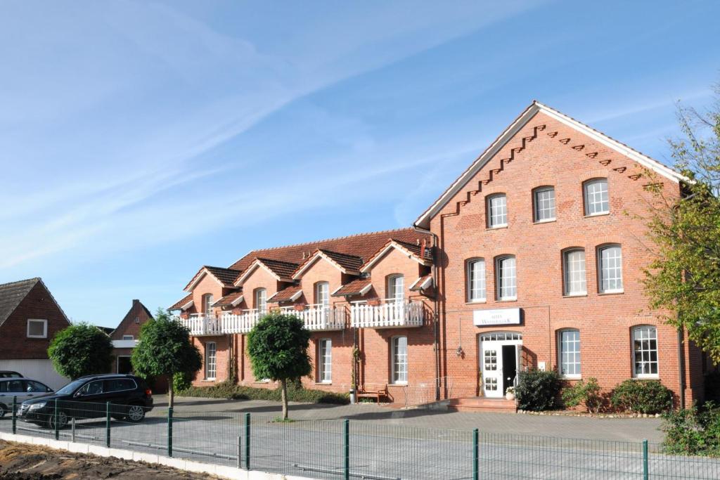 een bakstenen gebouw met auto's geparkeerd voor het bij das alte Wasserwerk in Bad Bentheim