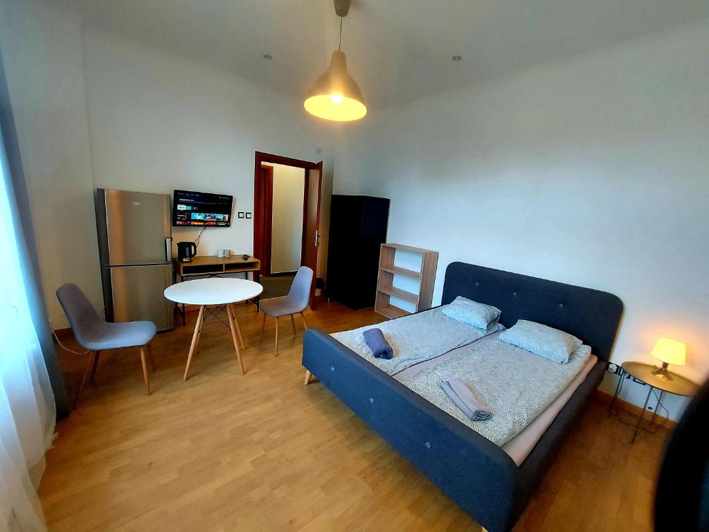 a room with a bed and a table and chairs at METRO Pokoje & Parking in Sopot