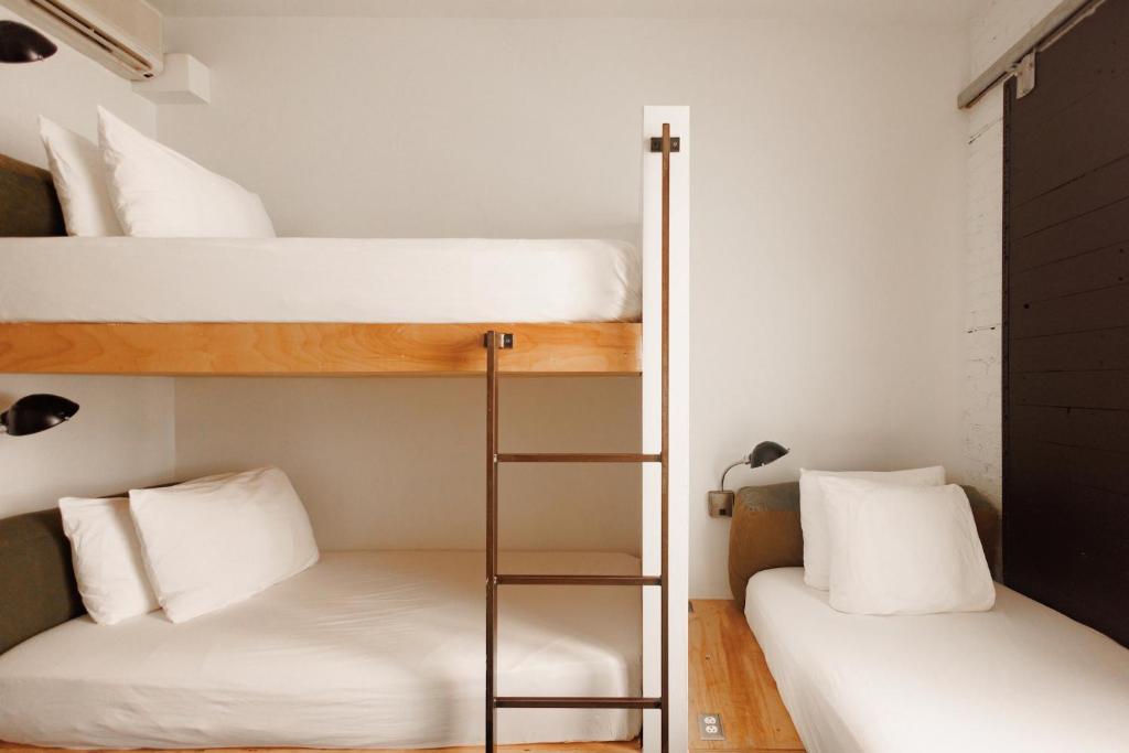 two bunk beds in a small room with a ladder at The Clyde Hotel Portland by Kasa Living in Portland