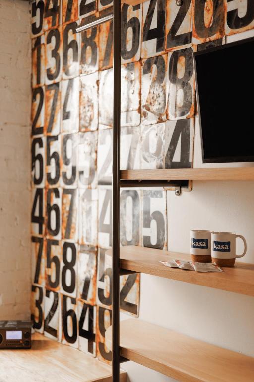 a shelf with a television and a wall with numbers at The Clyde Hotel Portland by Kasa Living in Portland