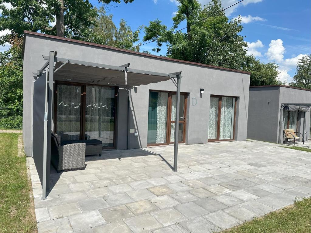 a building with a patio with a canopy at Domki Pasieka Domek C in Przeczyce