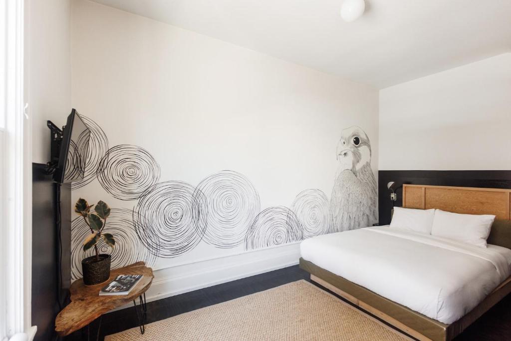 a bedroom with a bed and a wall with a bird mural at The Clyde Hotel Portland by Kasa Living in Portland