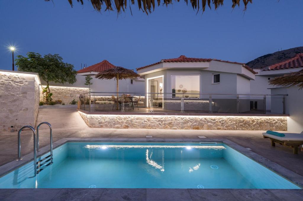 a villa with a swimming pool in front of a house at Ilios Villa Private Pool by ILIOS Georgioupoli in Georgioupoli