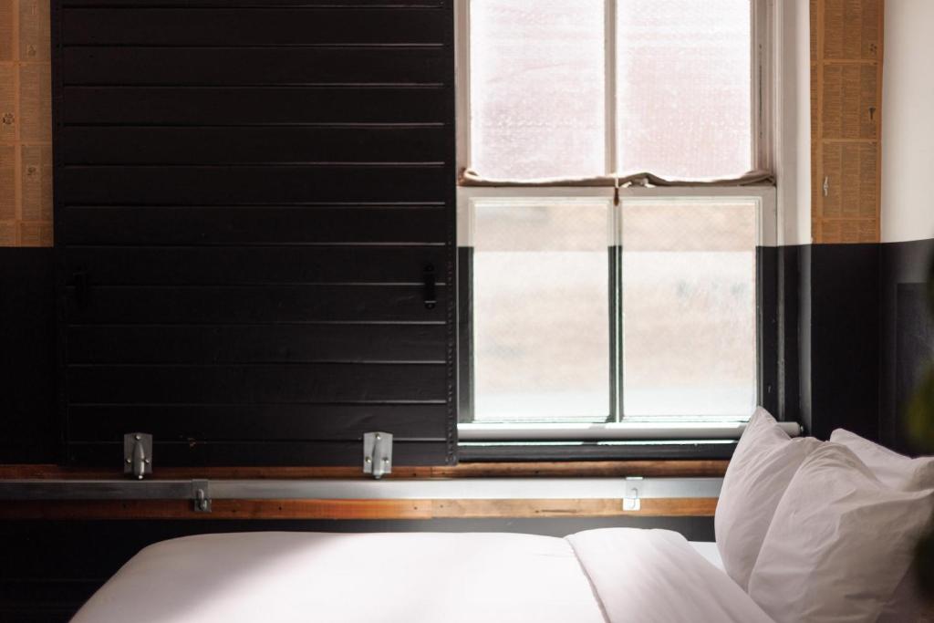 a bedroom with a window and a bed with white pillows at The Clyde Hotel Portland by Kasa Living in Portland