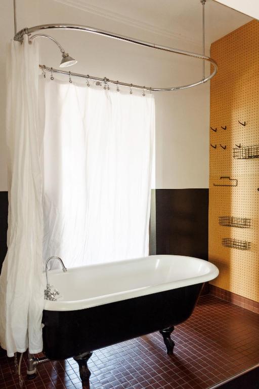 a bath tub in a bathroom with a window at The Clyde Hotel Portland by Kasa Living in Portland