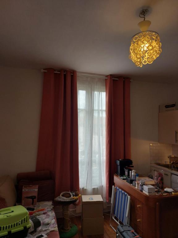 - un salon avec des rideaux rouges et une fenêtre dans l'établissement Lumineux, à Vitry-sur-Seine