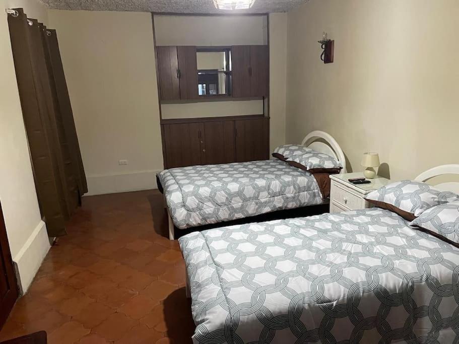 a room with two beds and a mirror at Hogar Parroquia in Guatemala