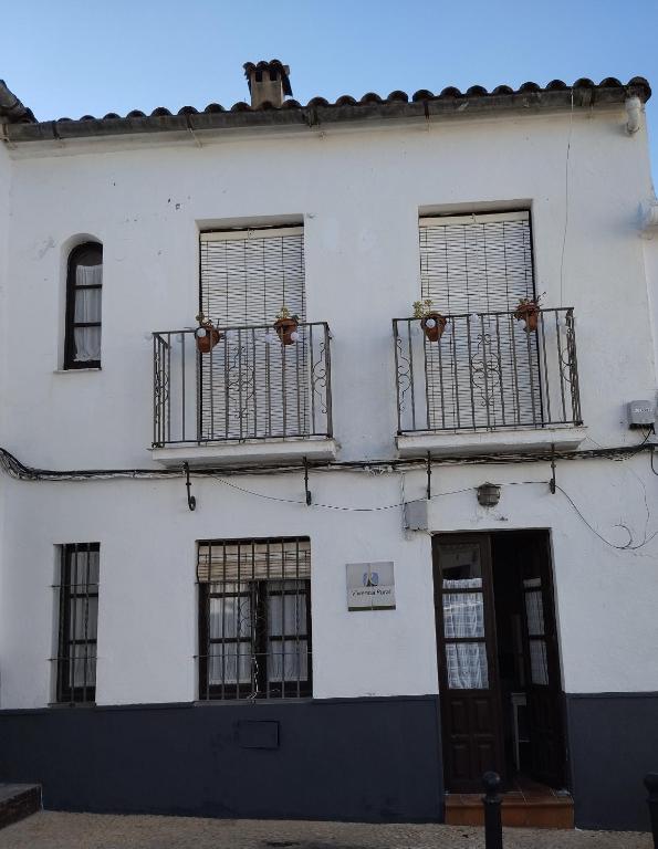 a white building with two balconies and a door at El rinconcito in Fuenteheridos