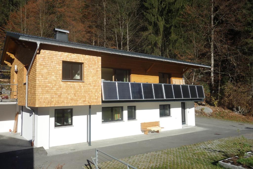 una casa con paneles solares en el techo en Caroline's Appartement, en Au im Bregenzerwald