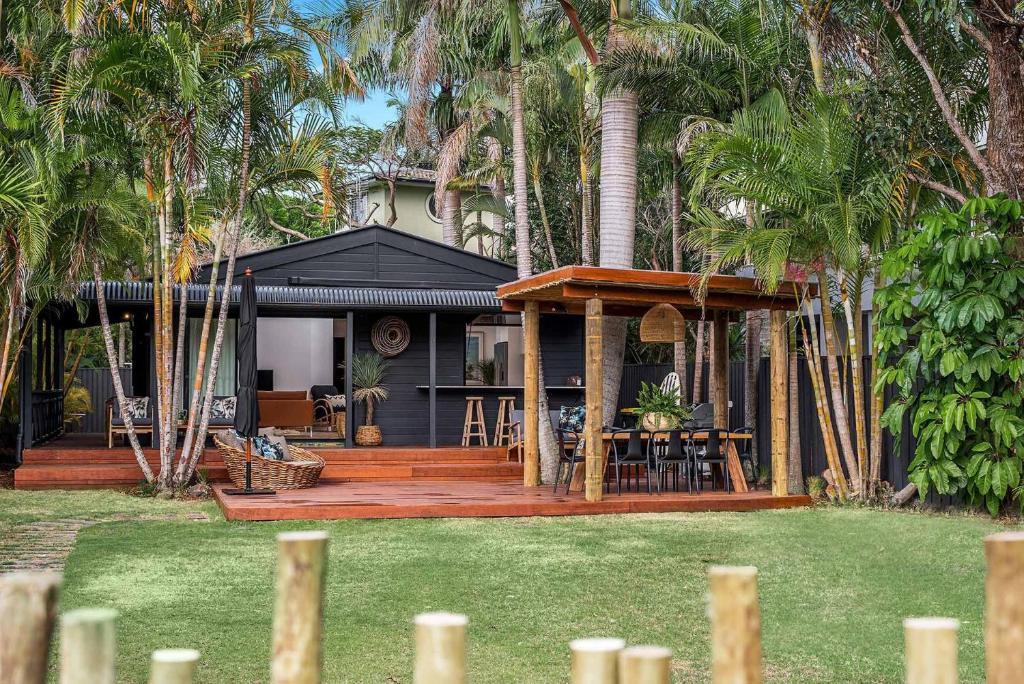 a house with a deck with a table and chairs at 3 Salty Sisters in Byron Bay