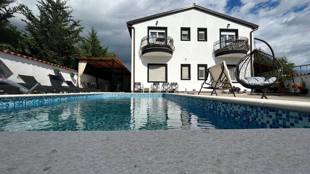 ein Haus mit einem Swimmingpool vor einem Gebäude in der Unterkunft Family friendly apartments with a swimming pool Pula - 22040 in Pula