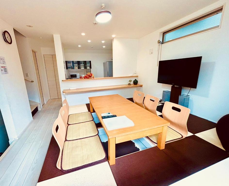 a living room with a wooden table and chairs at Convertel Honhaneda by Tranova in Tokyo